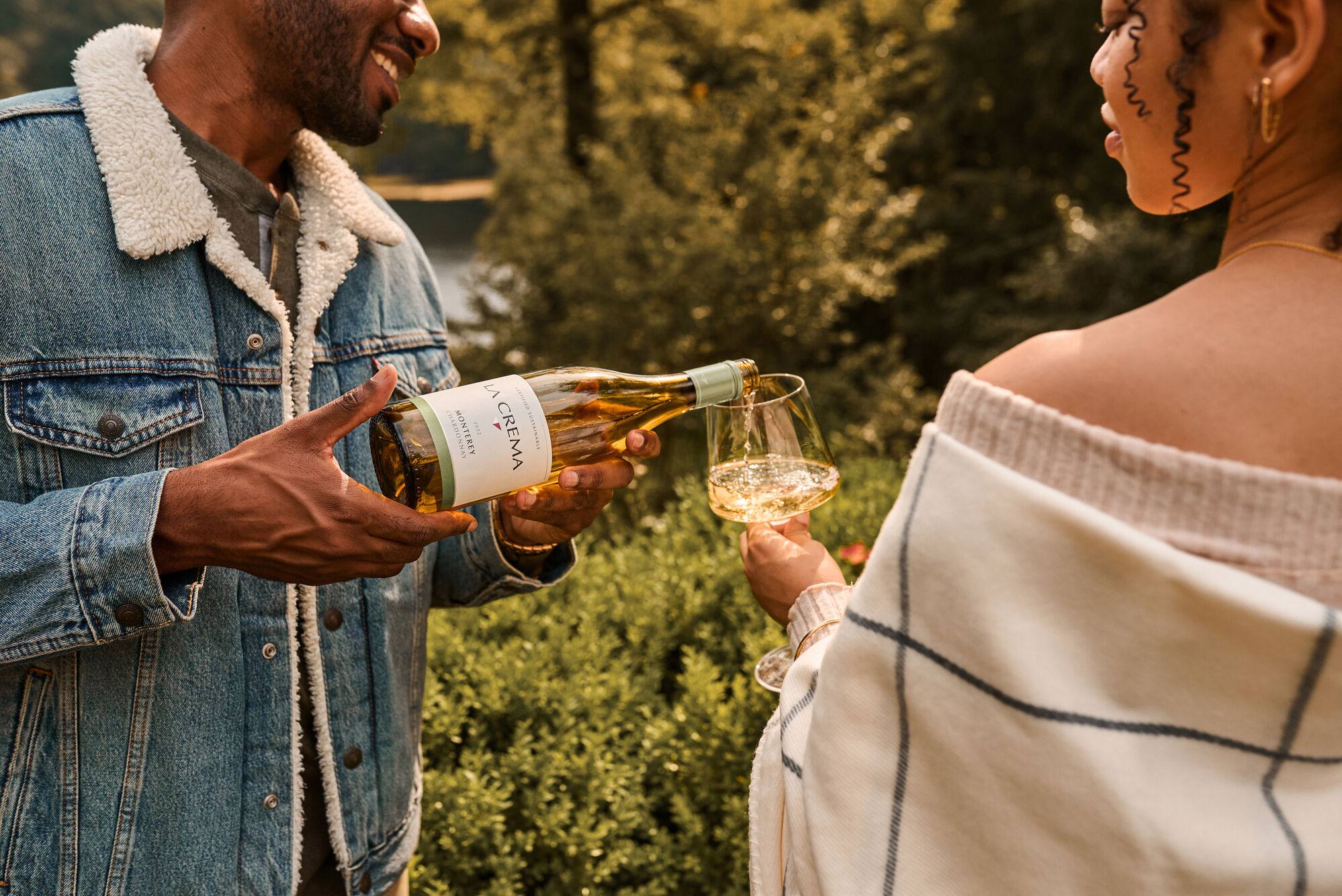 A couple pouring a bottle of La Crema Chardonnay
